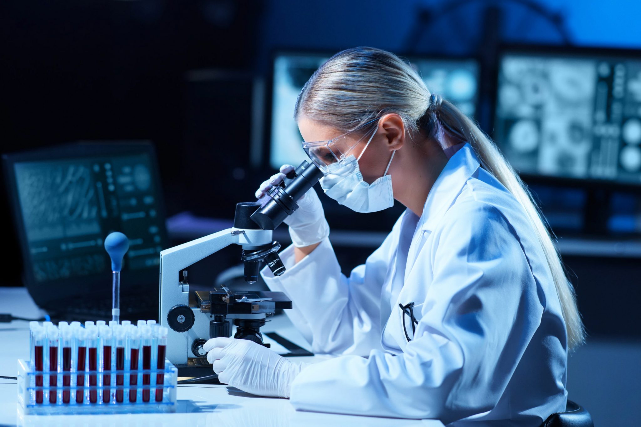 Female scientist working in modern lab. Doctor making microbiology research. Laboratory tools: microscope, test tubes, equipment. Coronavirus covid-19, bacteriology, virology, dna and health care.