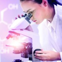 Female scientist looking through electron microscope