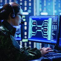 Female in camoflage operating computer in data center